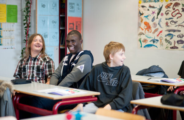 kinderen zitten in een klaslokaal, zij lachen