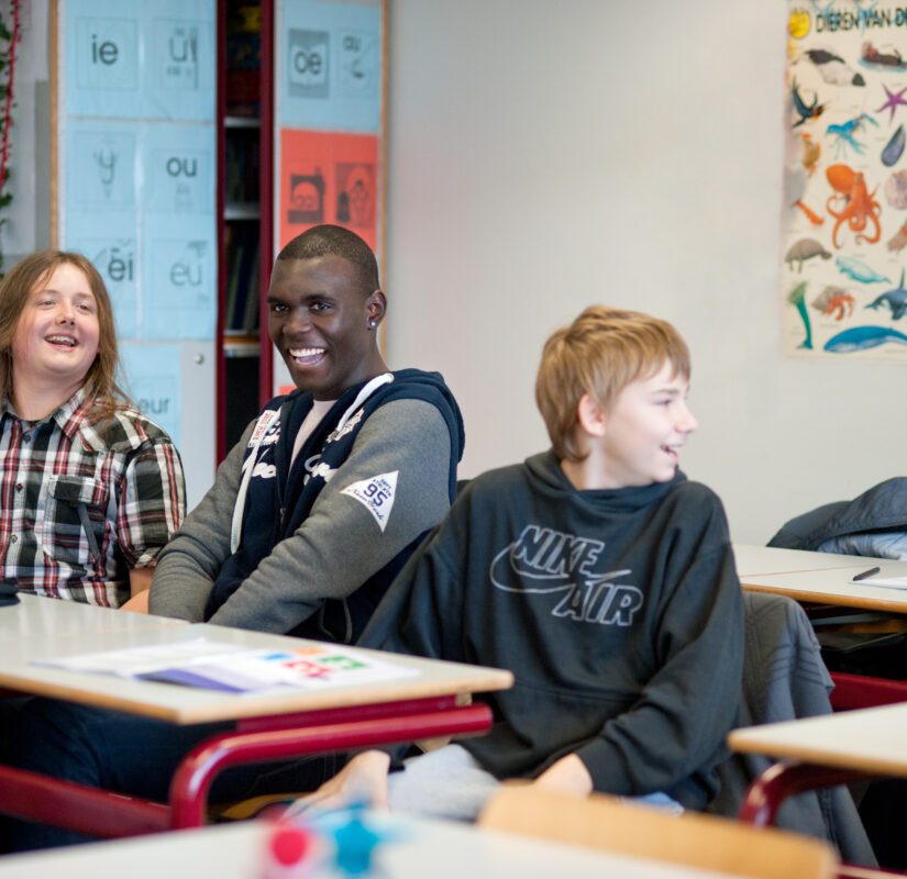 kinderen zitten in een klaslokaal, zij lachen